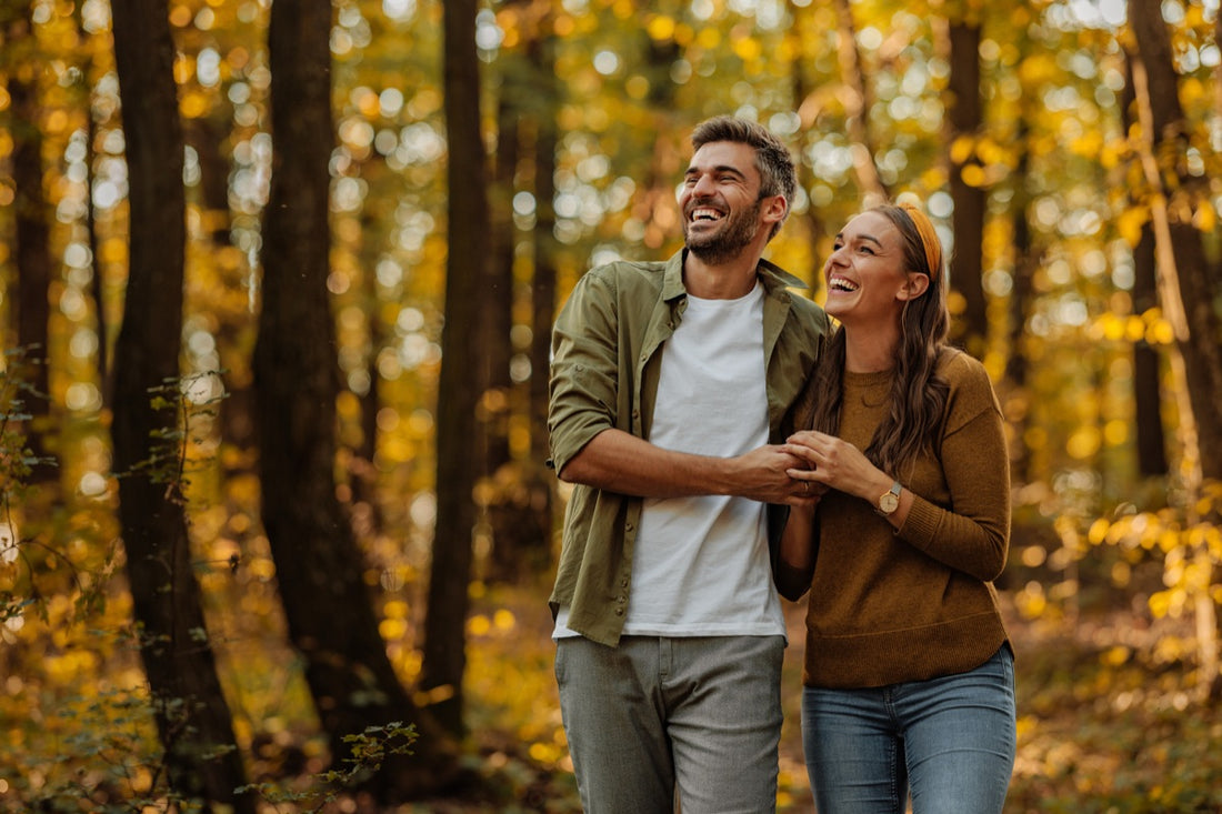 Lachendes Paar beim Herbstspaziergang im Wald